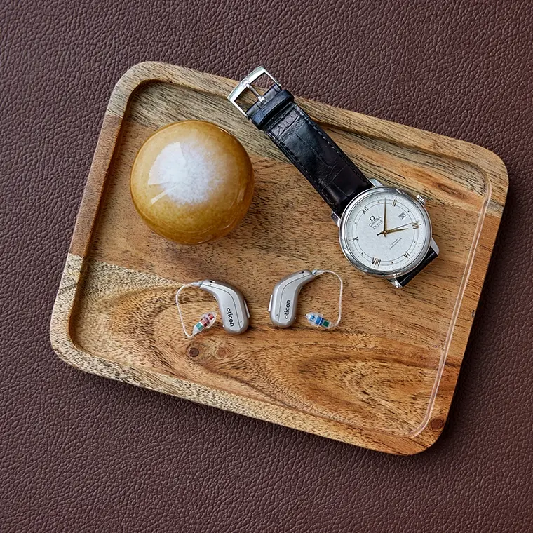 Oticon Intent Hörgerät auf einem Tisch, Größenvergleich